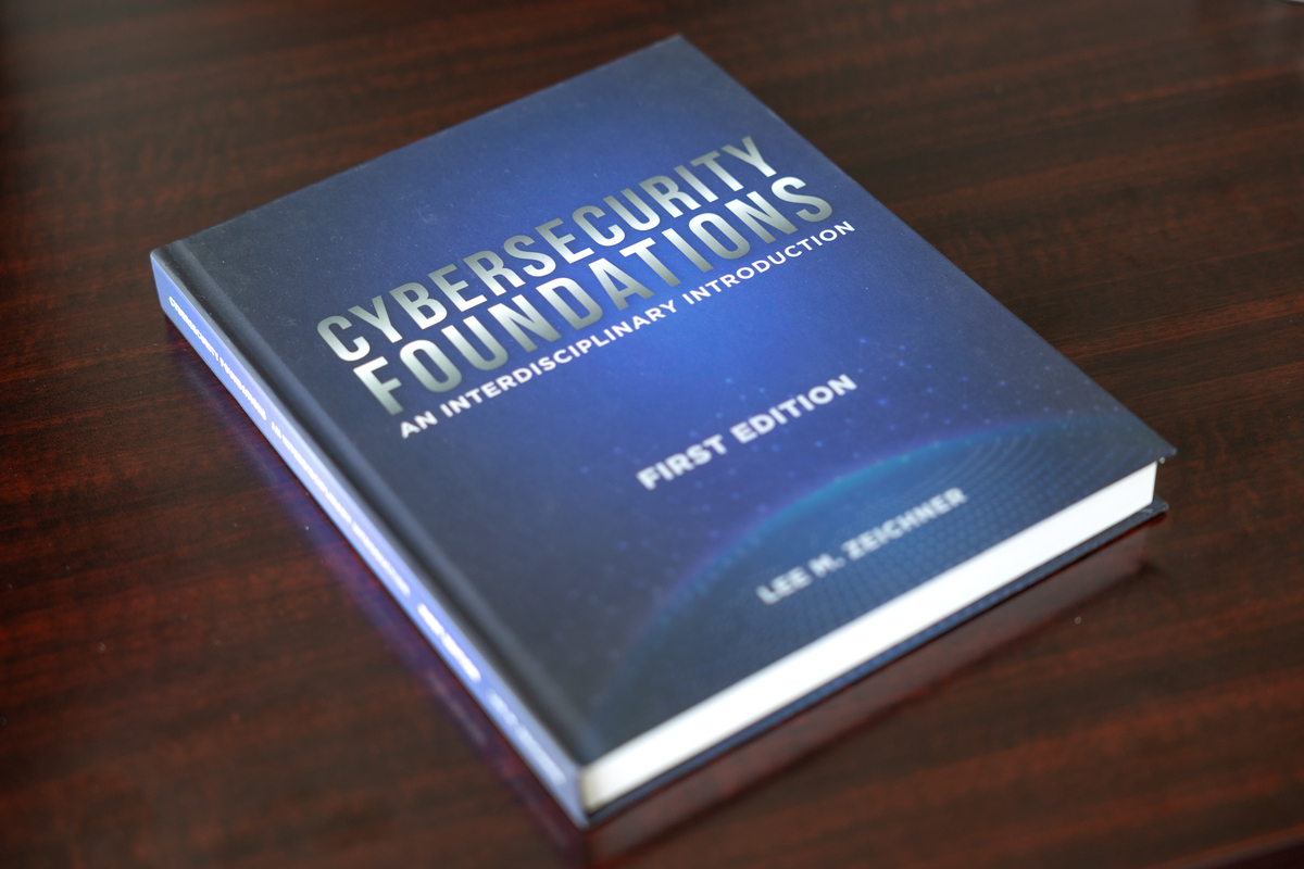 Blue hardcover cybersecurity textbook titled Cybersecurity Foundations Blue hardcover cybersecurity textbook titled Cybersecurity Foundations