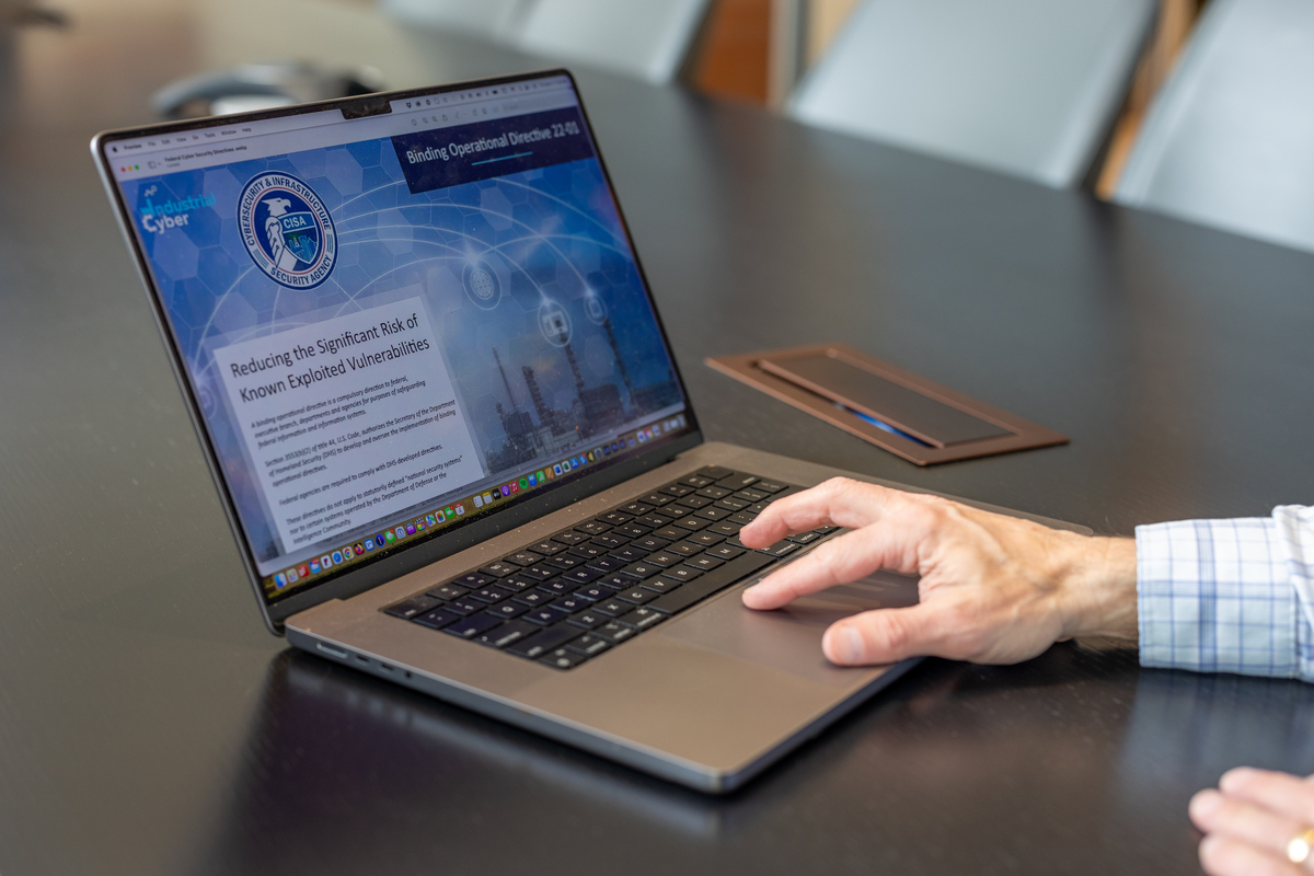 Laptop screen with CISA webpage and hand on trackpad Laptop screen with CISA webpage and hand on trackpad
