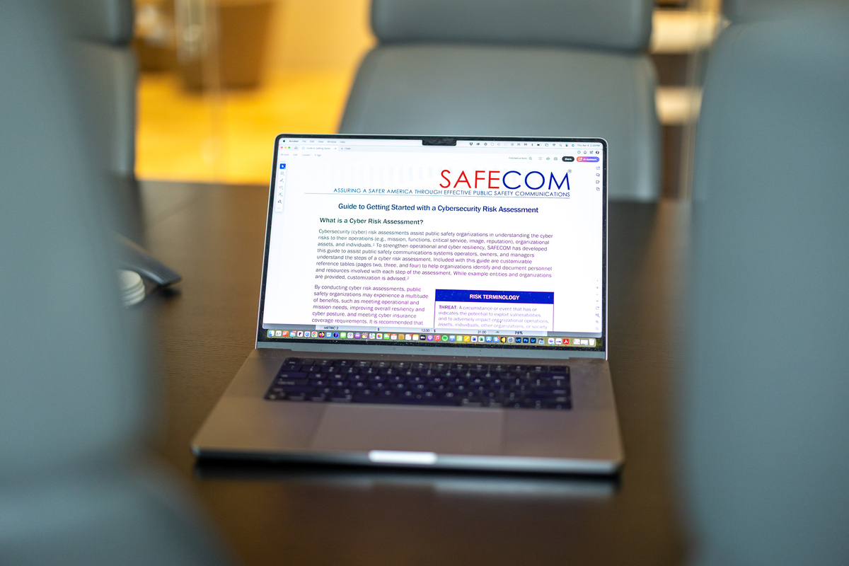 Conference room table with laptop screen showing SAFECOM webpage Conference room table with laptop screen showing SAFECOM webpage
