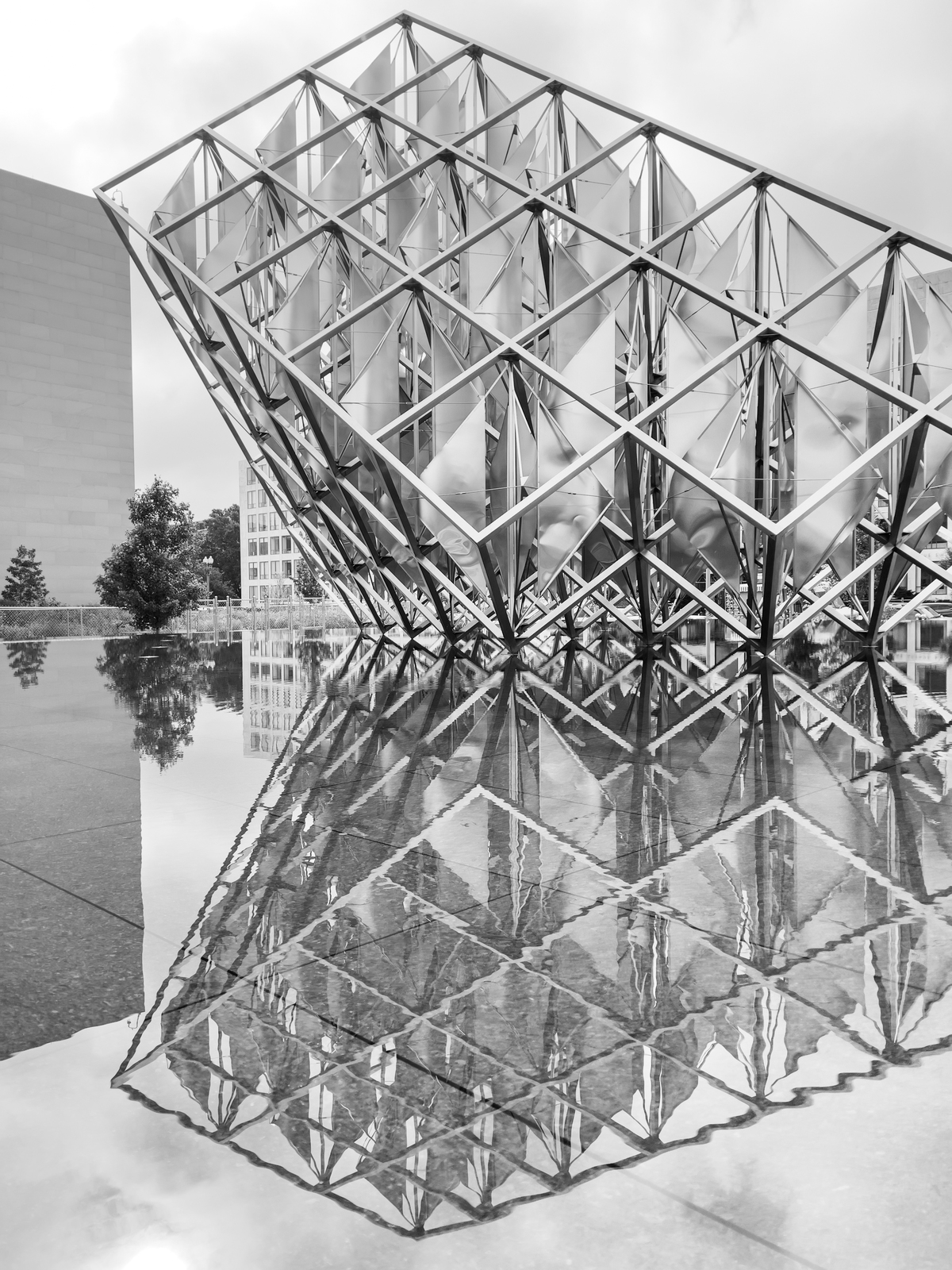 Grayscale statue of stacked open cubes built on a slant