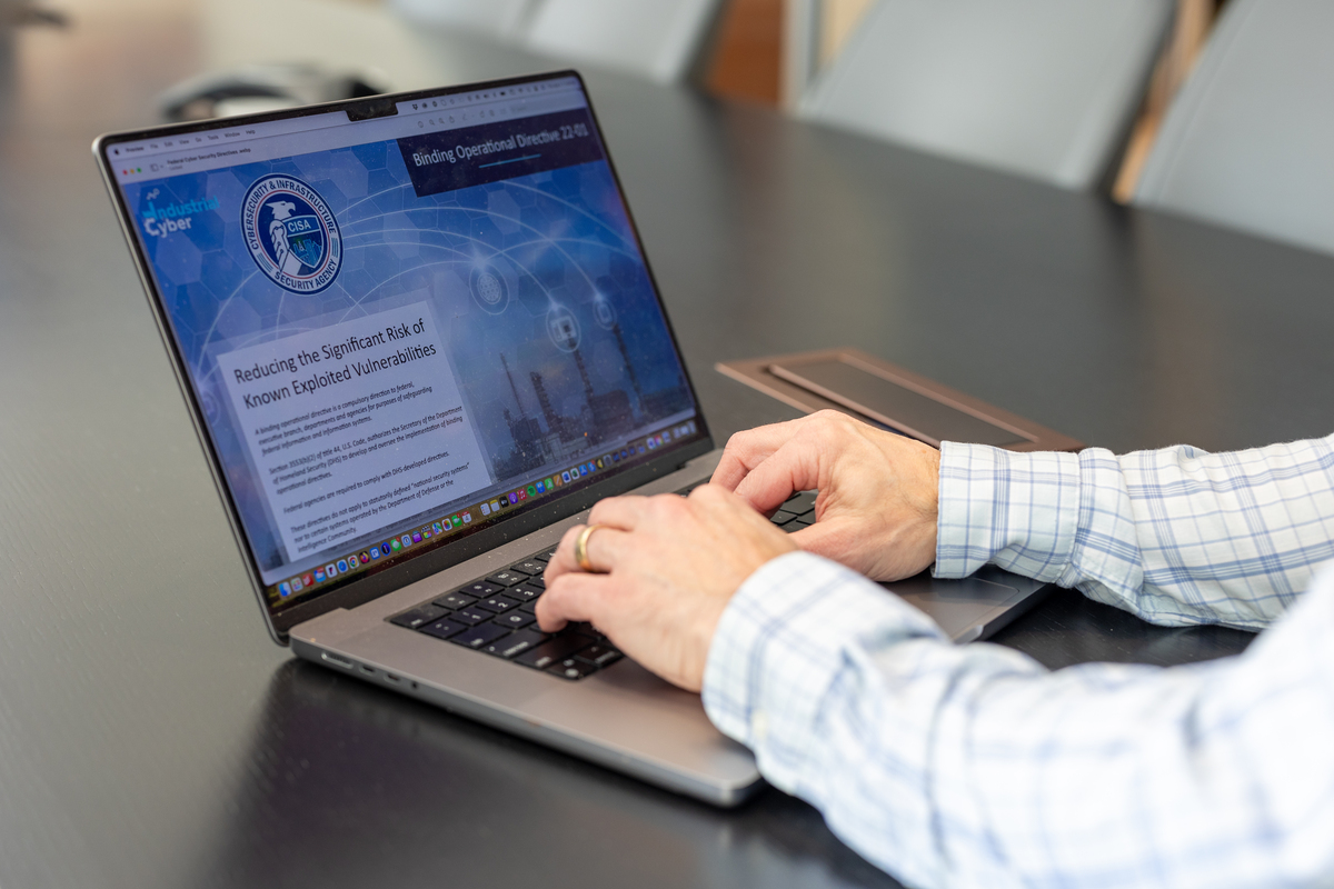 Laptop screen with CISA webpage and hands on keyboard